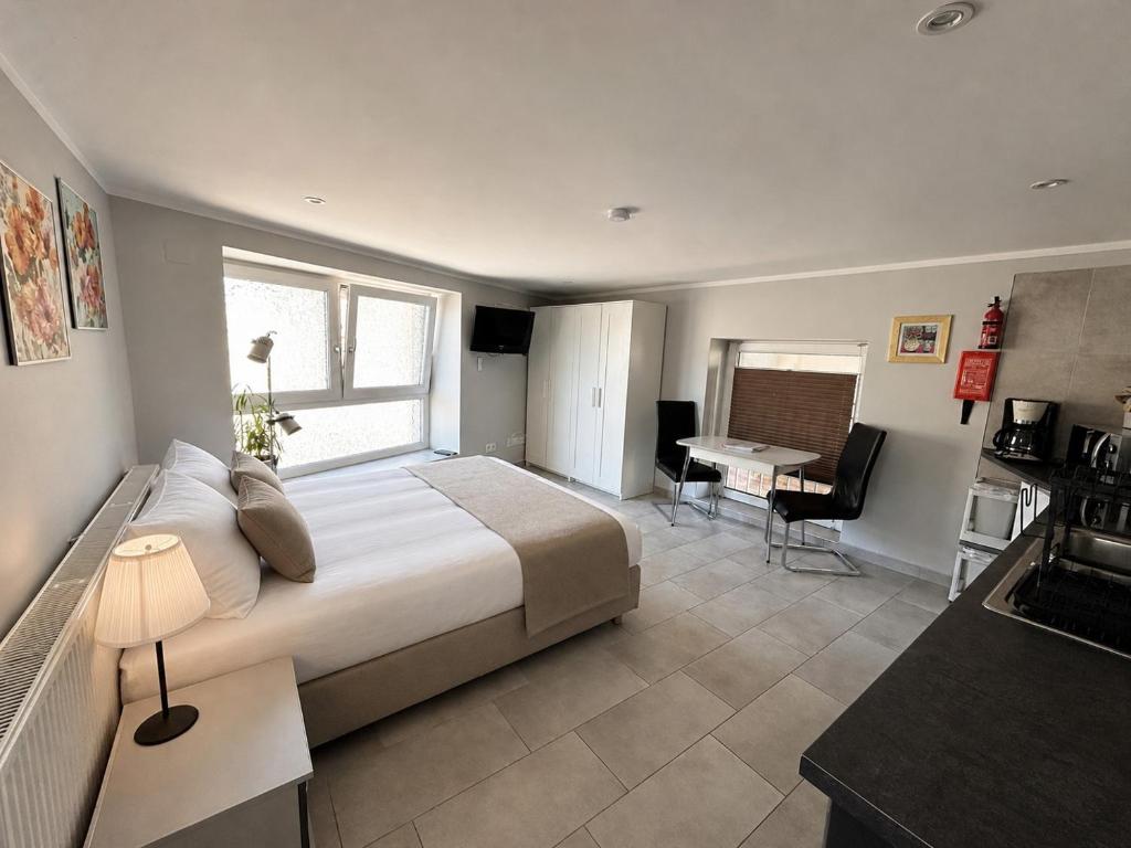 a bedroom with a large bed and a desk and a table at Am kleinen Storchennest in Ummendorf