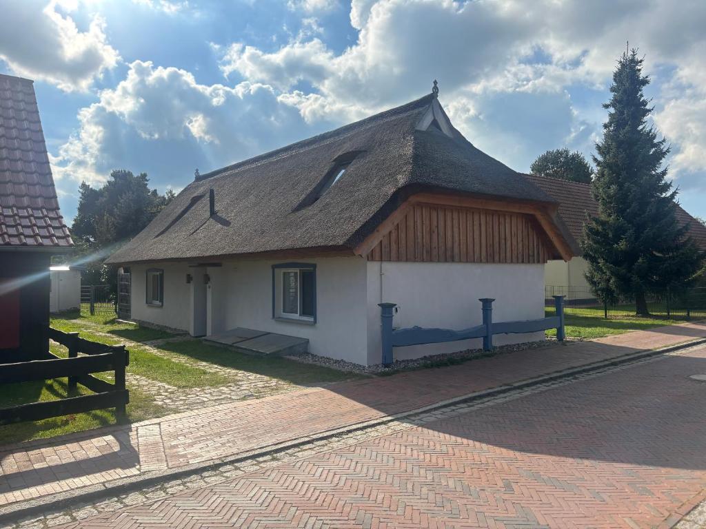 a small house with a roof on a street at Haus Wünsche in Wieck