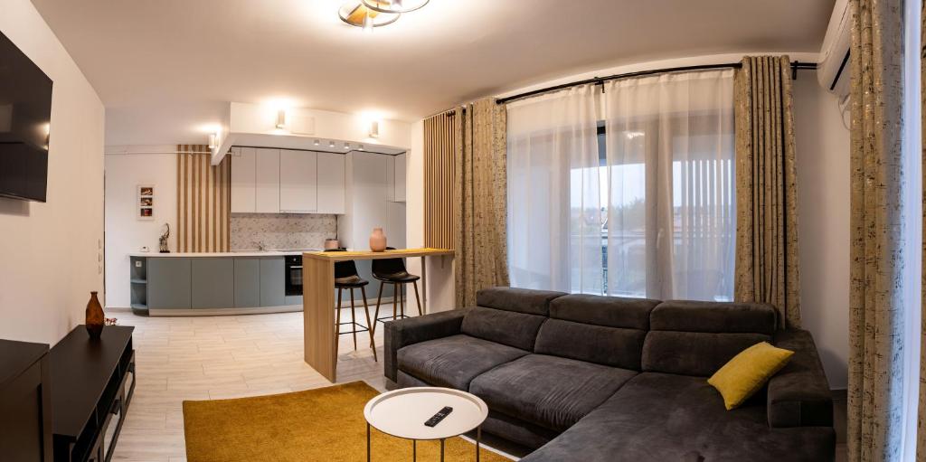 a living room with a couch and a kitchen at Modern 2BR Balcony View Pipera in Voluntari