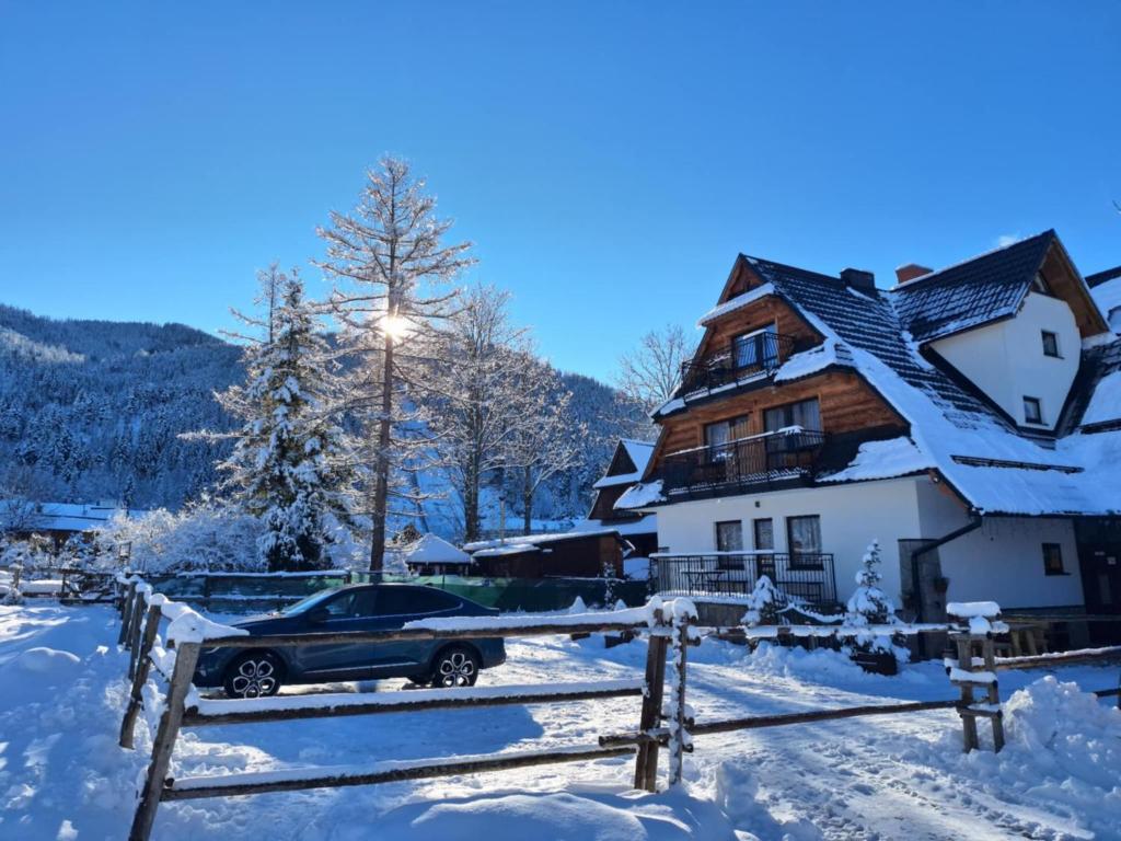 a car parked in front of a house in the snow at Willa Przy Skoczni in Zakopane