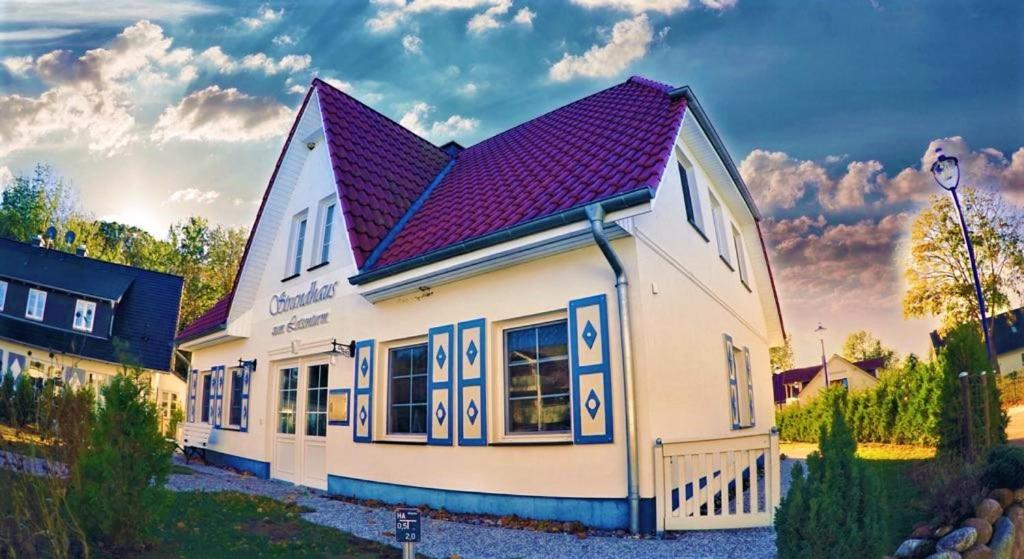 a large white building with a purple roof at Strandhaus zum Lotsenturm in Thiessow