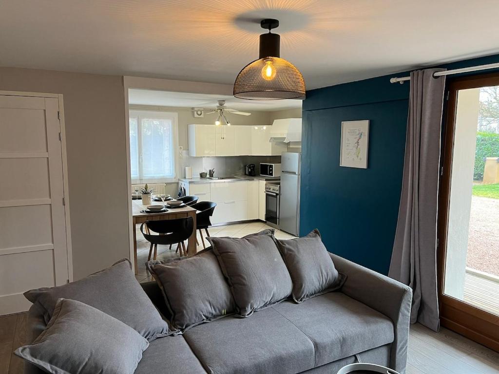 a living room with a couch and a kitchen at Logement indépendant avec jardin in Beaune