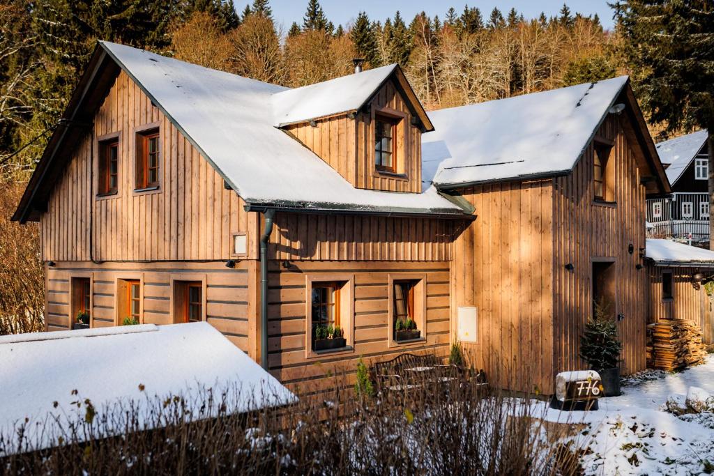 a wooden house with snow on the roof at Chalupa Mariánská hora 776 in Jablonec nad Nisou