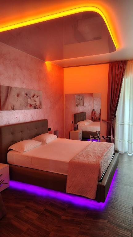 a bedroom with two beds with purple lights at B&B Luxury Suite Le Gladiaroom in Santa Maria Capua Vetere