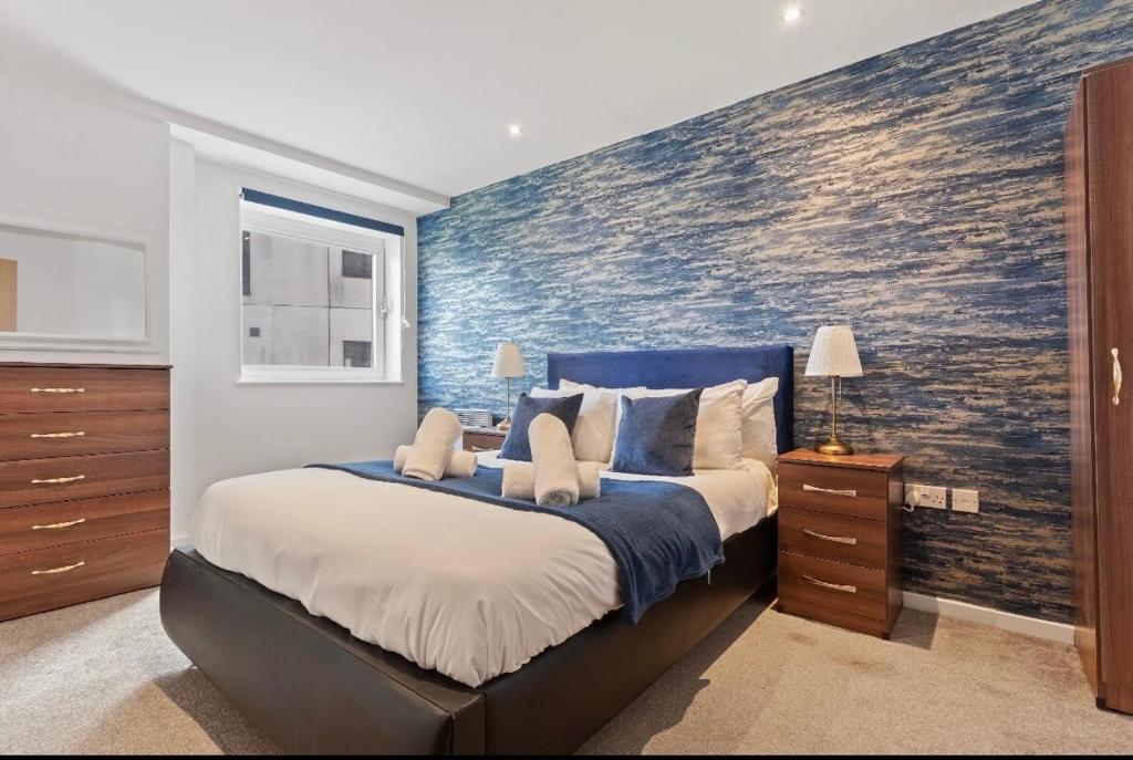 a bedroom with a large bed with a painting on the wall at Bright 2-BDR Apartment - Prime Central Location - Free Wi-Fi in Birmingham