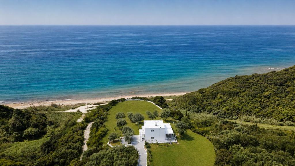 an aerial view of a house on a hill next to the ocean at Sunset apartment by the sea in Palaiochórion