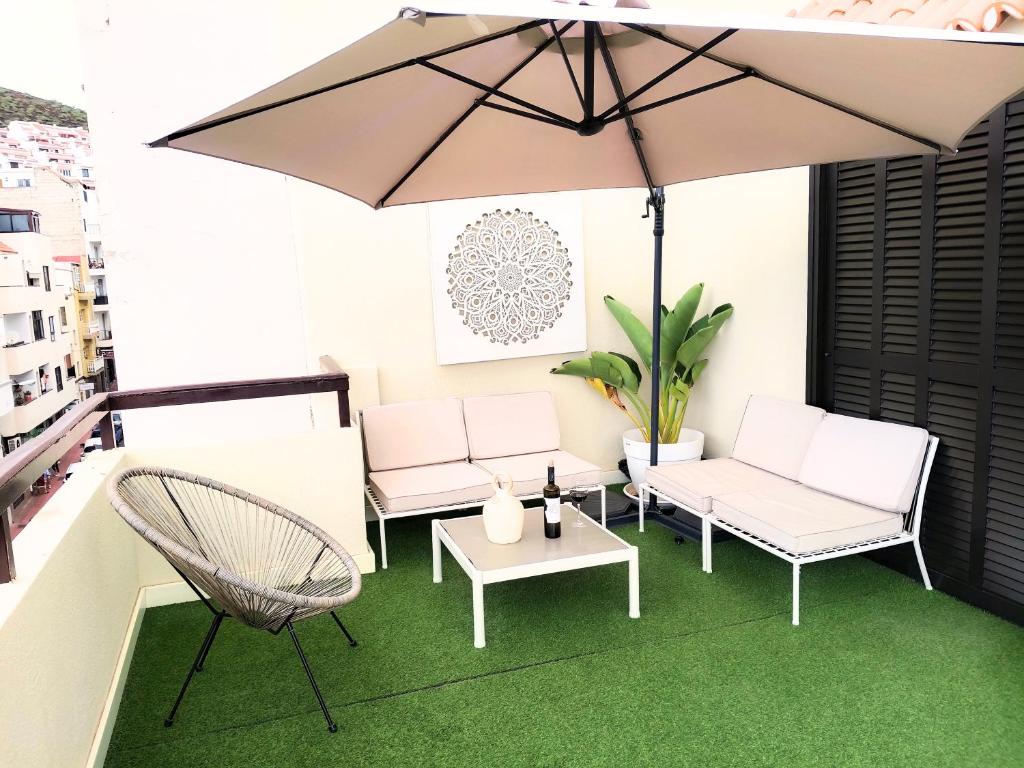 a patio with two chairs and an umbrella at Cozy & Terrace Apartament5 in Los Cristianos