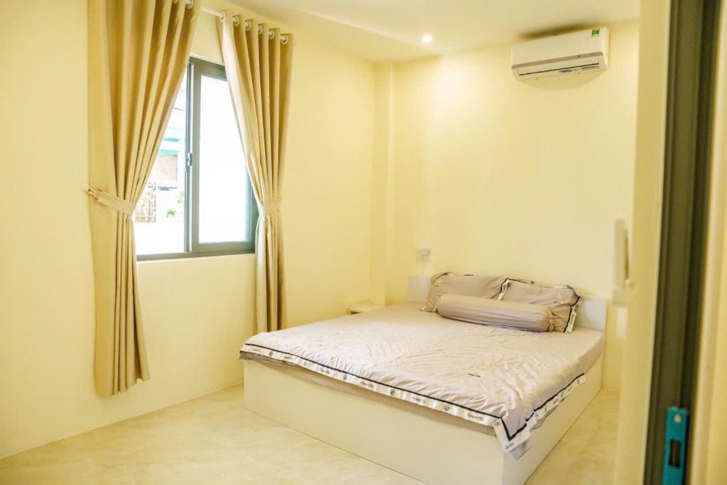 a small bedroom with a bed and a window at Libra House Phu Quoc in Phú Quốc