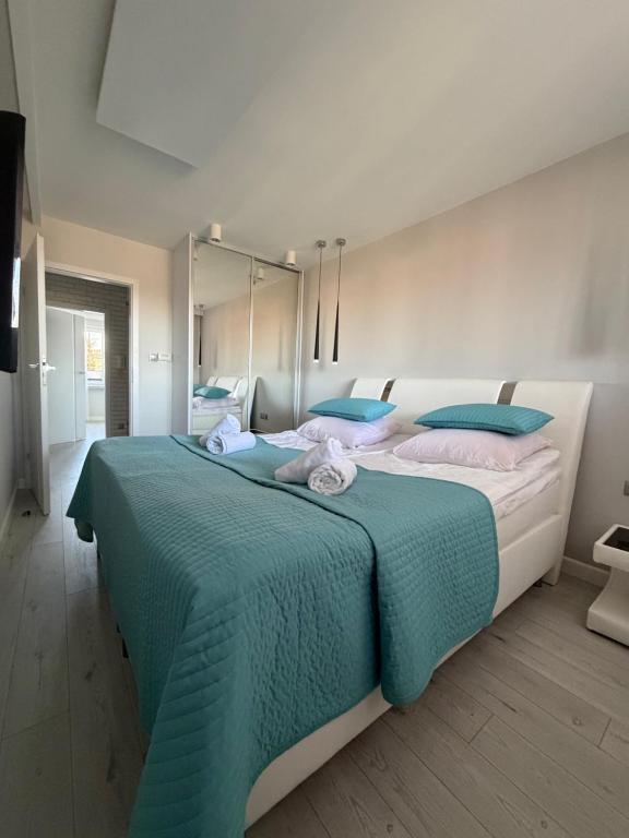 a bedroom with a large bed with blue pillows at Apartament Wczasowa 3 in Sarbinowo