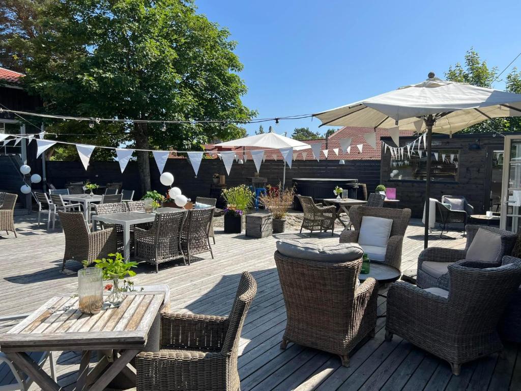 an outdoor patio with tables and chairs and umbrellas at Gottskär Hotell & Konferens in Onsala