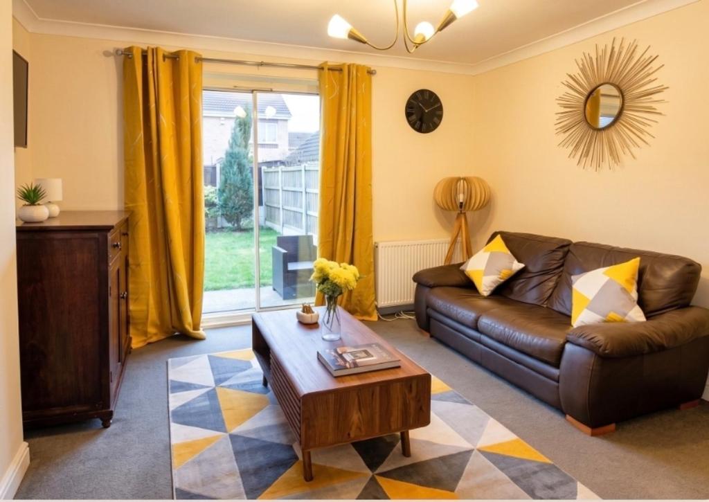 a living room with a couch and a table at 2 Bed Semi - Sleeps 4 - Fully Fenced Garden & Parking - Quiet Cul De Sac Location - Dog Friendly - Fast Wifi - Close to Motorway Access in Doncaster