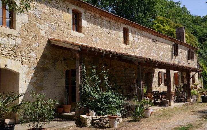 an old brick building with plants in front of it at La ferme des Perdilles in Biran