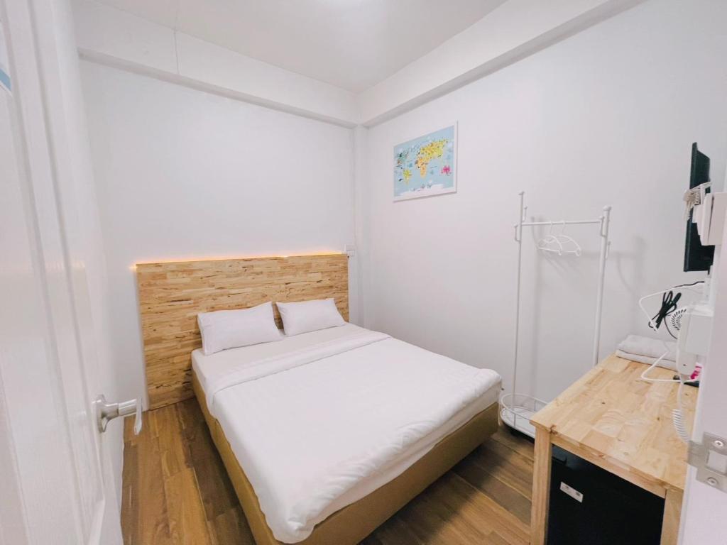 a small bedroom with a bed and a desk at latitude 14 Room & breakfast in Ban Bang Sakae