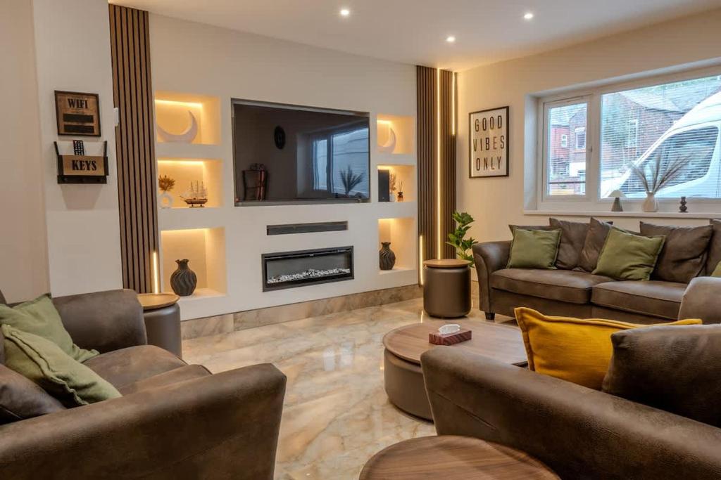a living room with two couches and a fireplace at Luxehaus MCR in Manchester