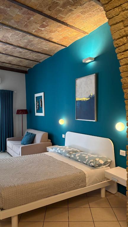a bedroom with two beds and a blue wall at Barbarossa Sea Room in Termoli
