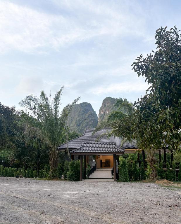 a house with a mountain in the background at Khaosok Unseen Resort in Khao Sok National Park