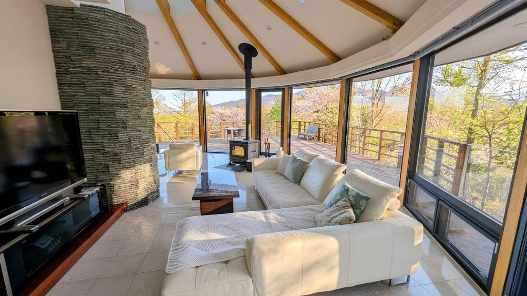 a living room with a white couch and a tv at Owners Hill B25 in Oiwake