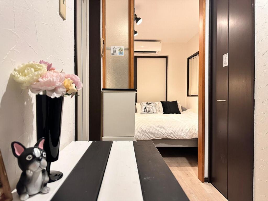 a room with a vase of flowers and a bedroom at Mori de house in kobe 302 in Kobe