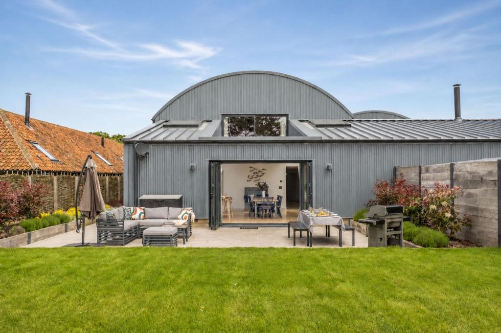 an exterior view of a metal building with a patio at Fitters Barn in Warham