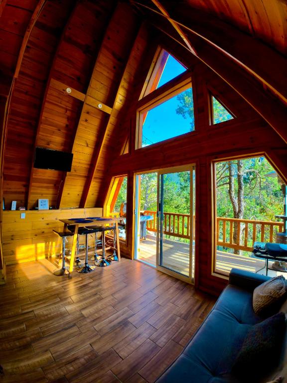 a living room with a table and some windows at Glamping MORET Cabaña Alpina M2 in Los Lirios