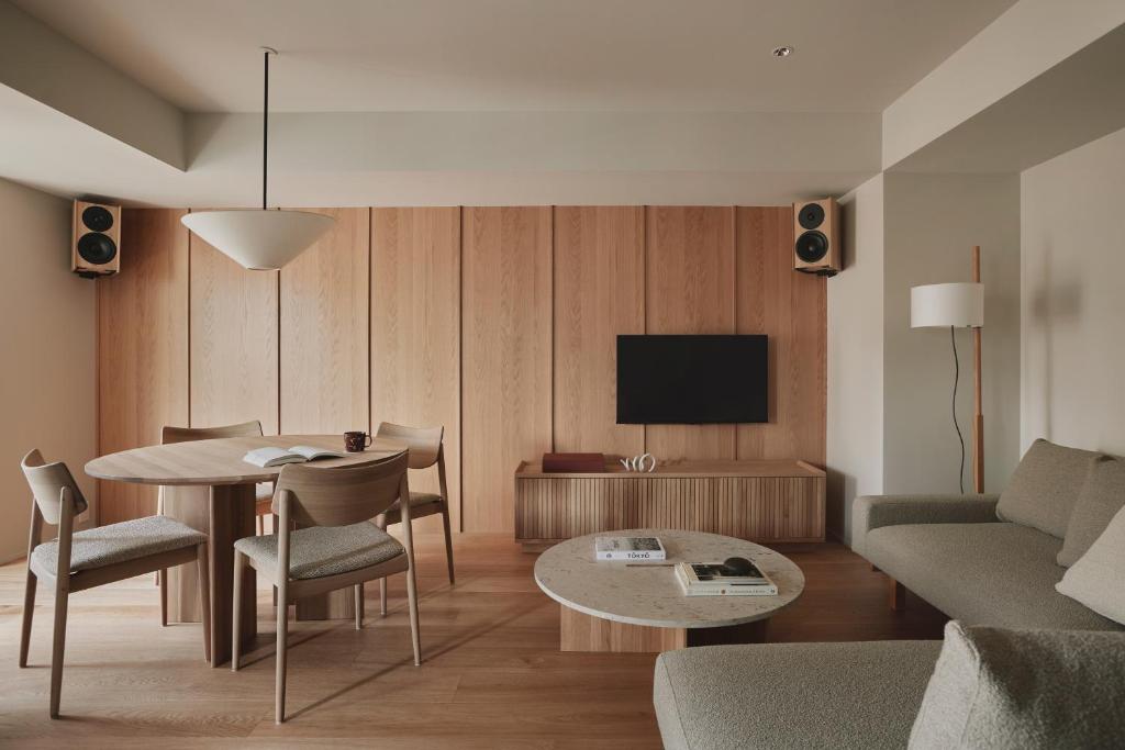 a living room with a table and a tv at TOMI Ginza in Tokyo
