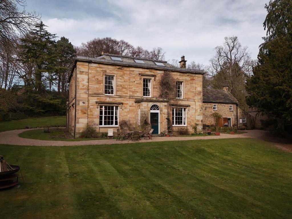 an old stone house with a grass yard at Burnhopeside Hall in Lanchester