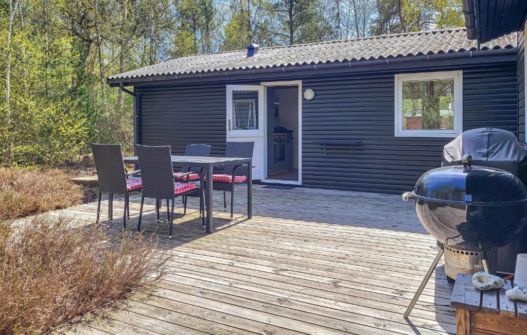 a black cabin with a table and chairs on a deck at Gorgeous Home In Læsø With Wifi in Læsø