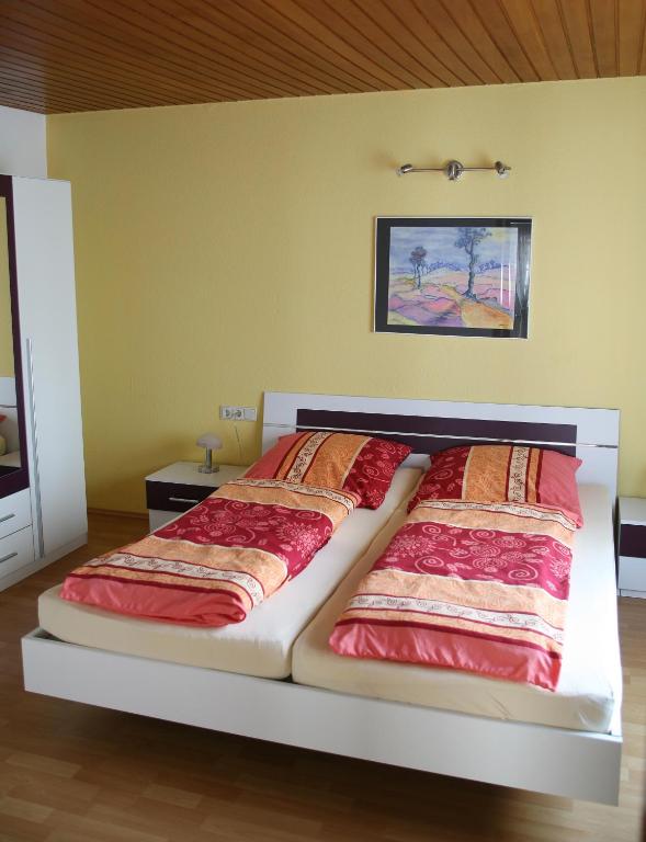 a bedroom with a large bed with red sheets at Ferienwohnung Neuber in Bad Kissingen