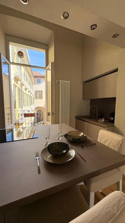 a kitchen with a table with two plates and wine glasses at Dimora del Loggiato in Acqui Terme