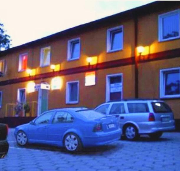 two cars parked in a parking lot in front of a building at Noclegi Lux Nysa in Nysa