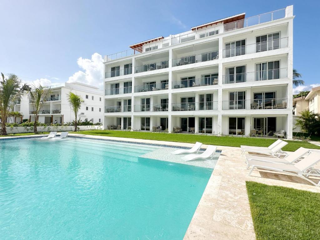 a building with a swimming pool in front of a building at Mananero Group Residence in Cabarete