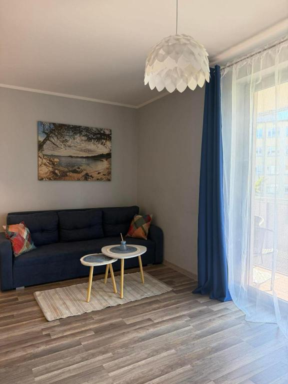 a living room with a blue couch and a table at Apartament Marco z balkonem in Oleśnica