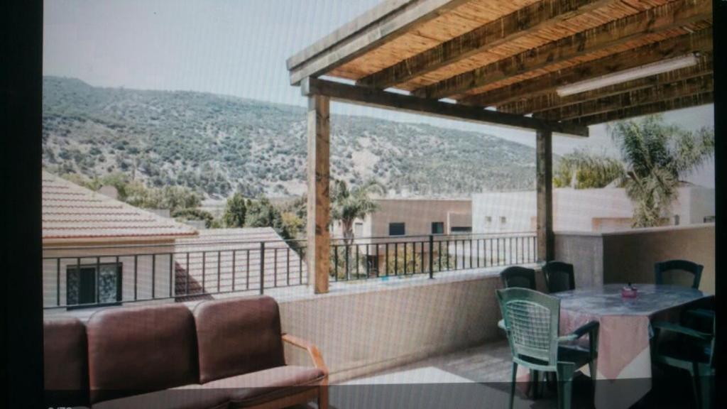 a patio with a table and chairs on a balcony at Ilana's Place in Qiryat H̱aroshet