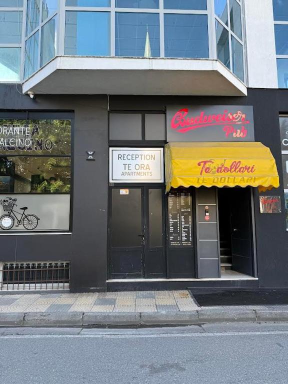 a store front of a building with a yellow awning at ORA Appartment's in Shkodër