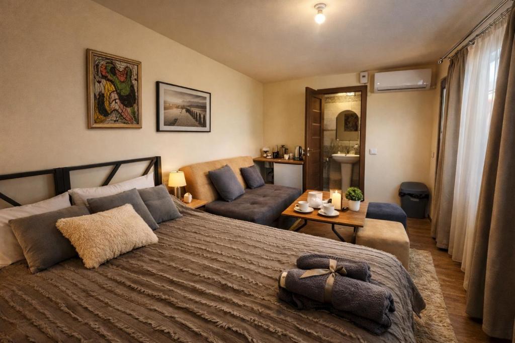a bedroom with a large bed and a living room at TEVRA Nature, Retreat Mountain Cabins Above the City Ijevan, Dilijan in Ijevan
