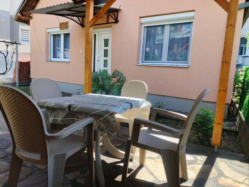 a table with chairs and an umbrella on a patio at Apartman Kutak in Pirot