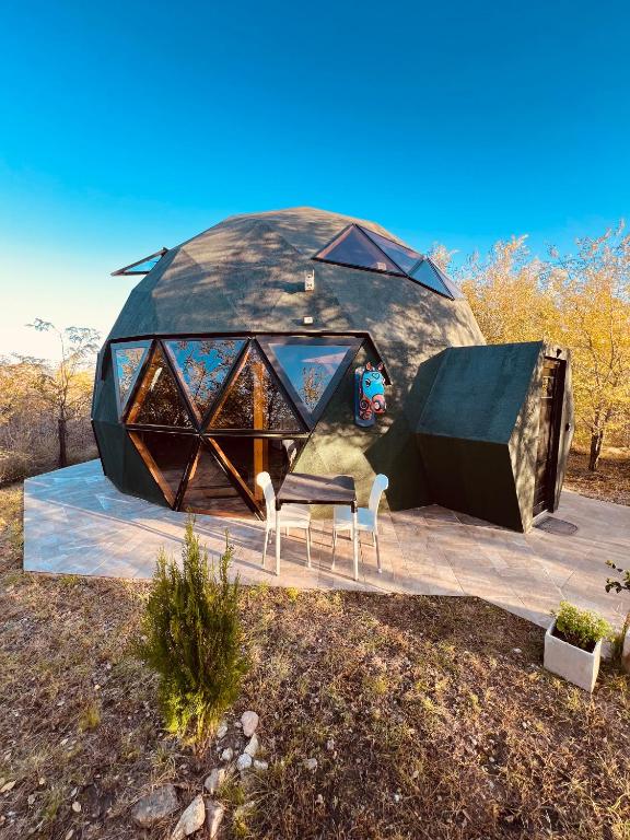 a dome house in the middle of a field at Domo Del Rio in Los Reartes