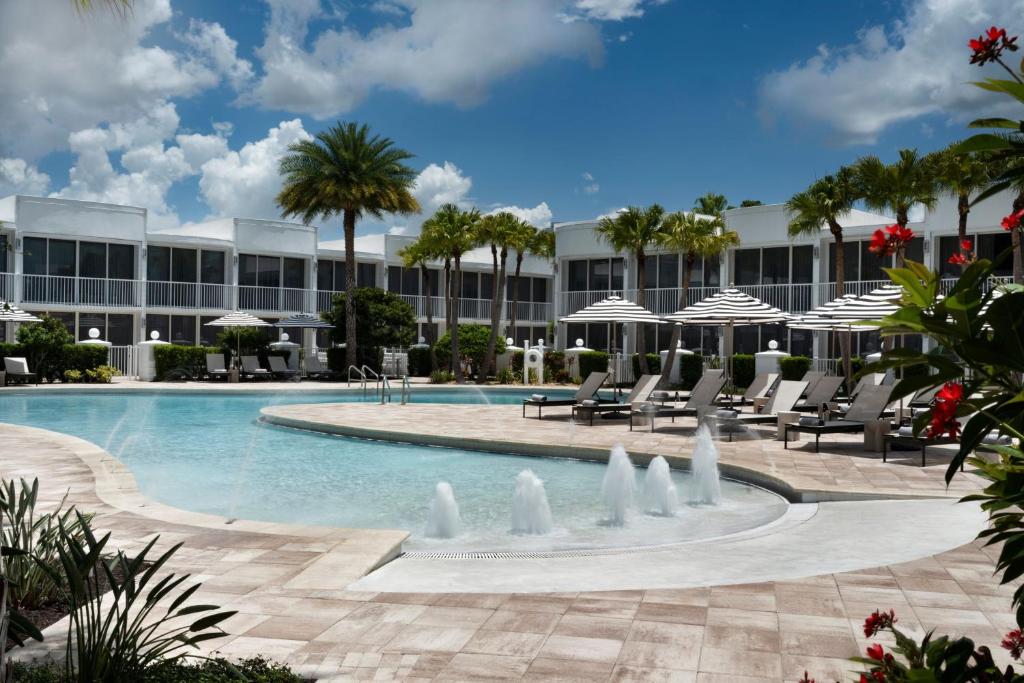 a pool at a resort with chairs and umbrellas at Renaissance Orlando Resort - Disney Springs Area - Free Shuttle & Early Entry to Disney Theme Parks in Orlando