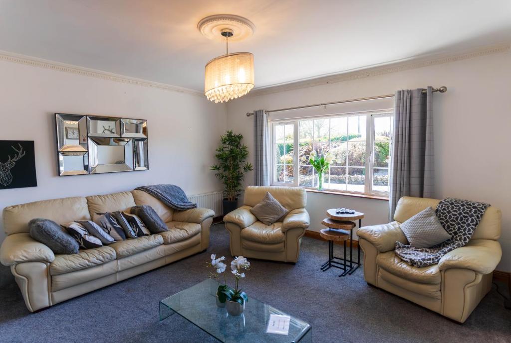 a living room with couches and chairs and a window at Foxhill - Valentia in Valentia Island