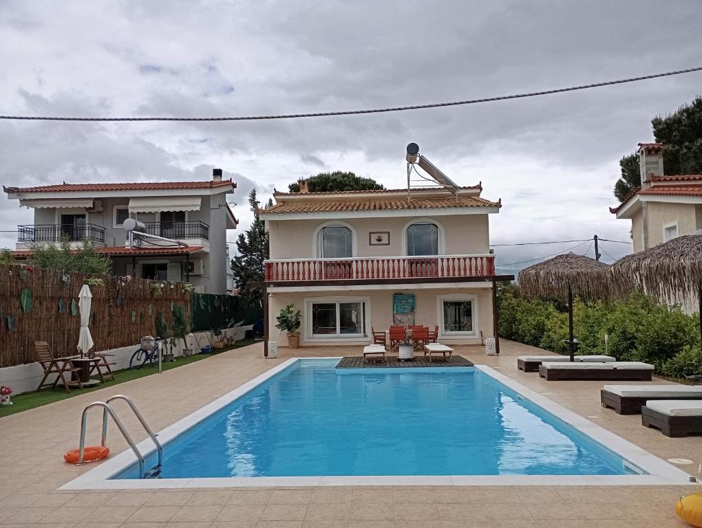 a house with a swimming pool in front of a house at Villa Evenik in Eretria