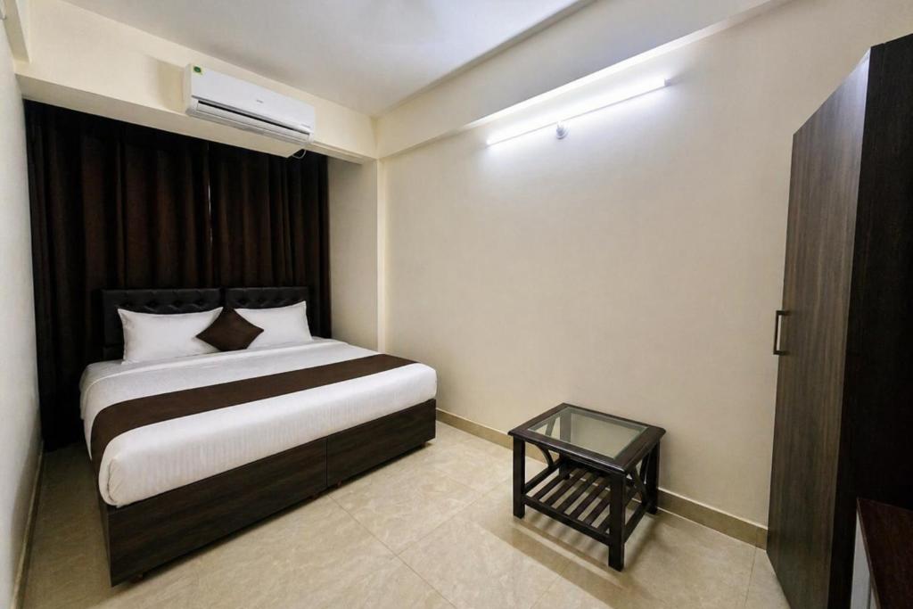 a bedroom with a bed and a glass table at Hotel L ! M Calangute Beach Way in Calangute