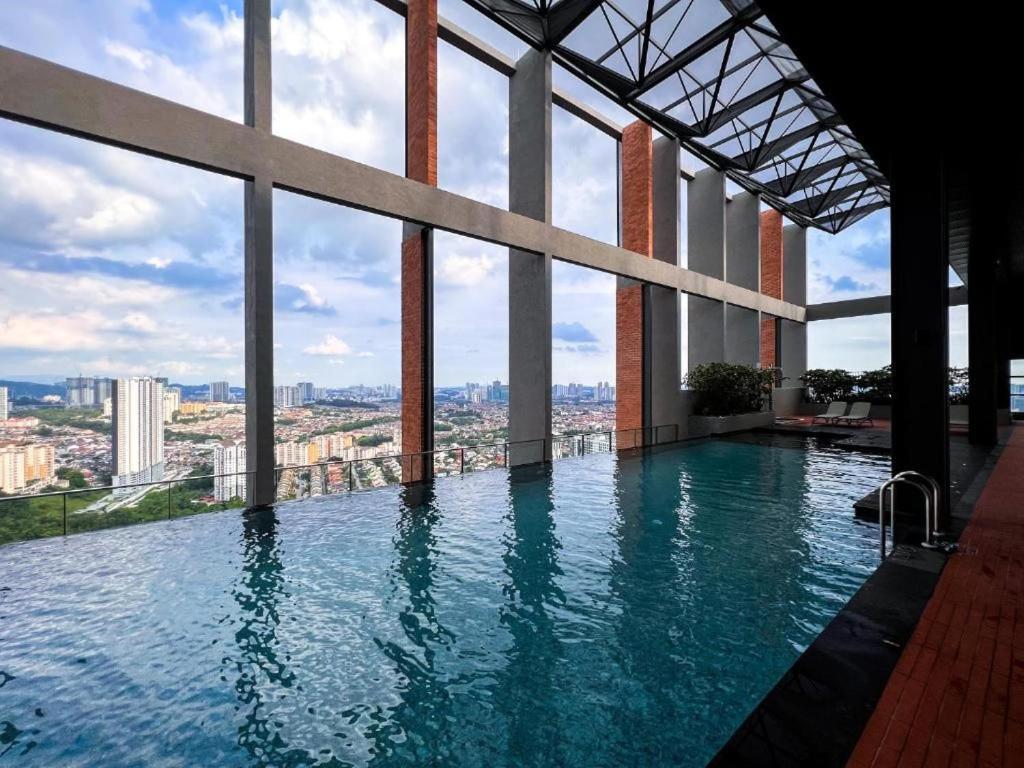 a large swimming pool in a building with windows at Miller Cozy Home in Kuala Lumpur