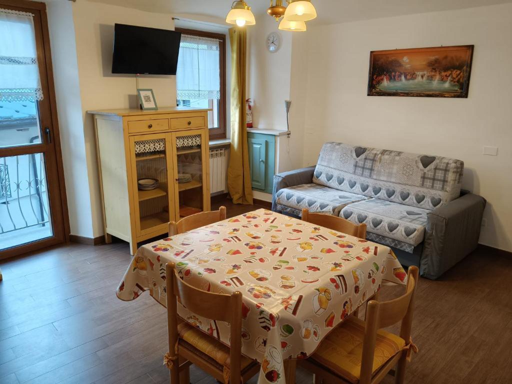 a living room with a table and a couch at Centro - La Tana di Nico & Chri in Bardonecchia