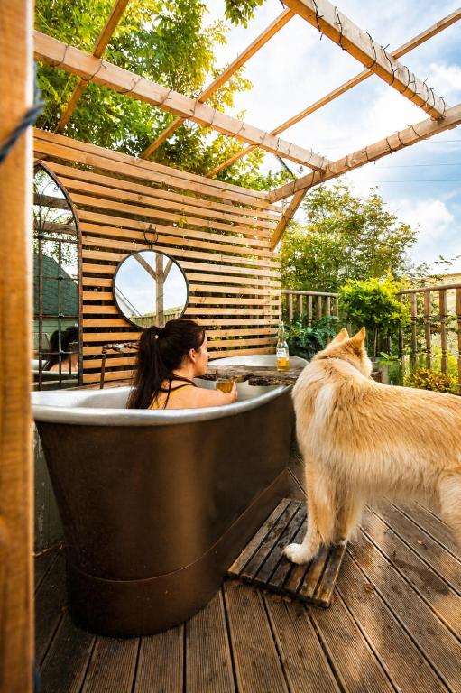 a woman sitting in a bath tub with a cat at 2 - Luxury Escape - Outdoor bathtub and sauna under the stars! in Pont Sticill