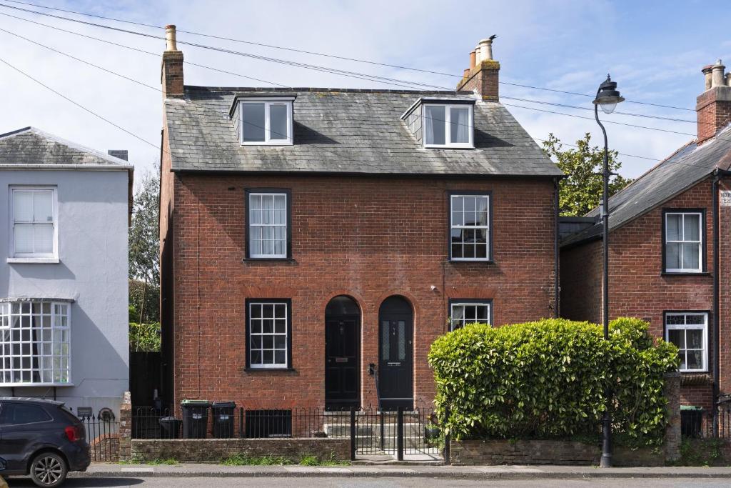 a red brick house with a gray roof at Ace Cottage in Lymington
