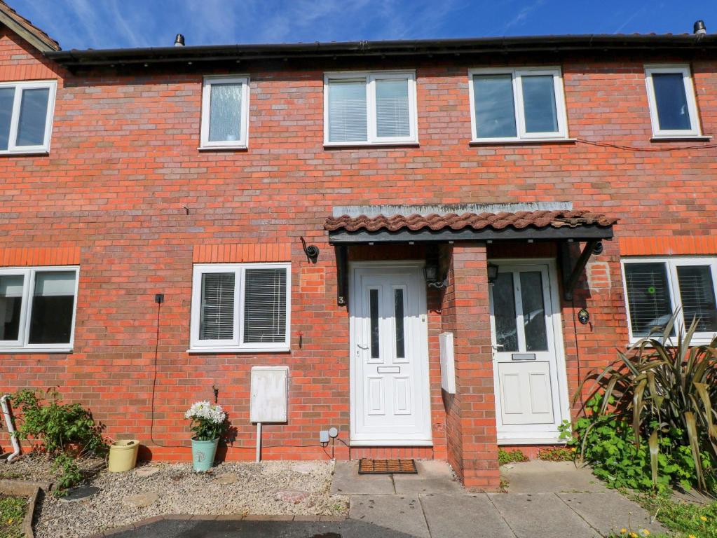 a red brick house with white doors and windows at The Gower Gateway in Swansea
