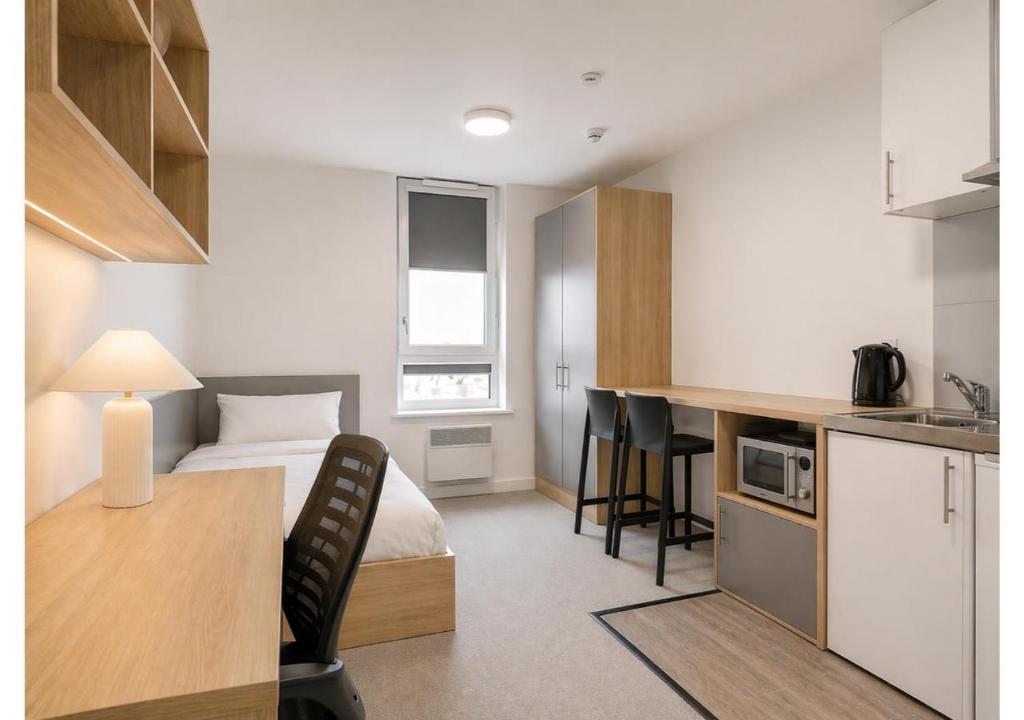 a small apartment with a bed and a kitchen at Globeworks by UTDM in Birmingham
