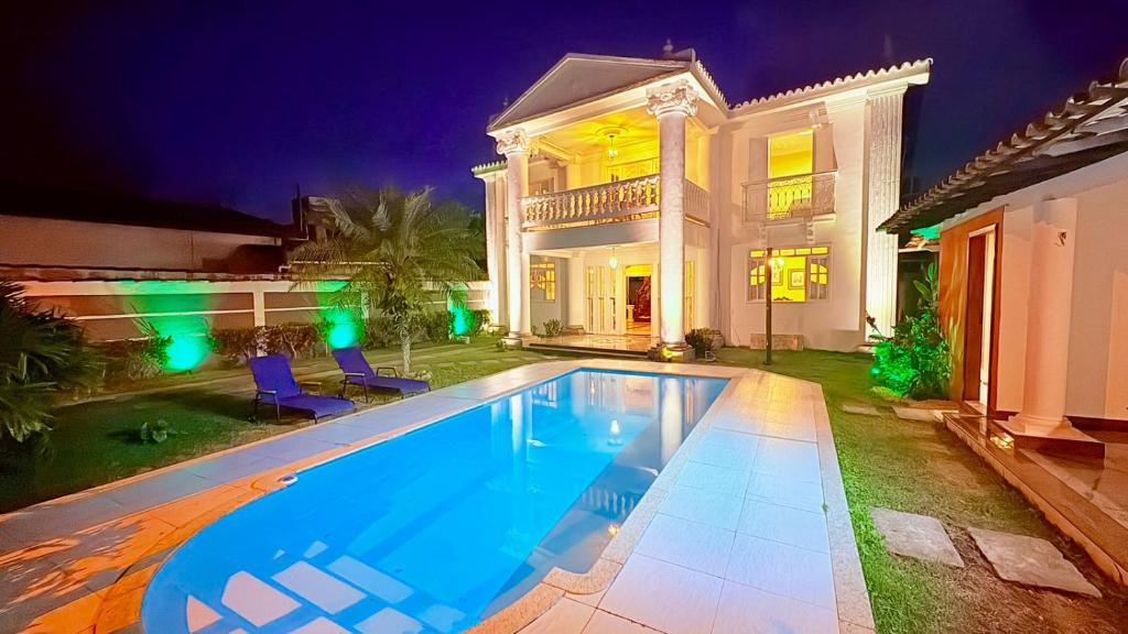 a large swimming pool in front of a house at Terra do Sol Pousada - Passarela in Porto Seguro