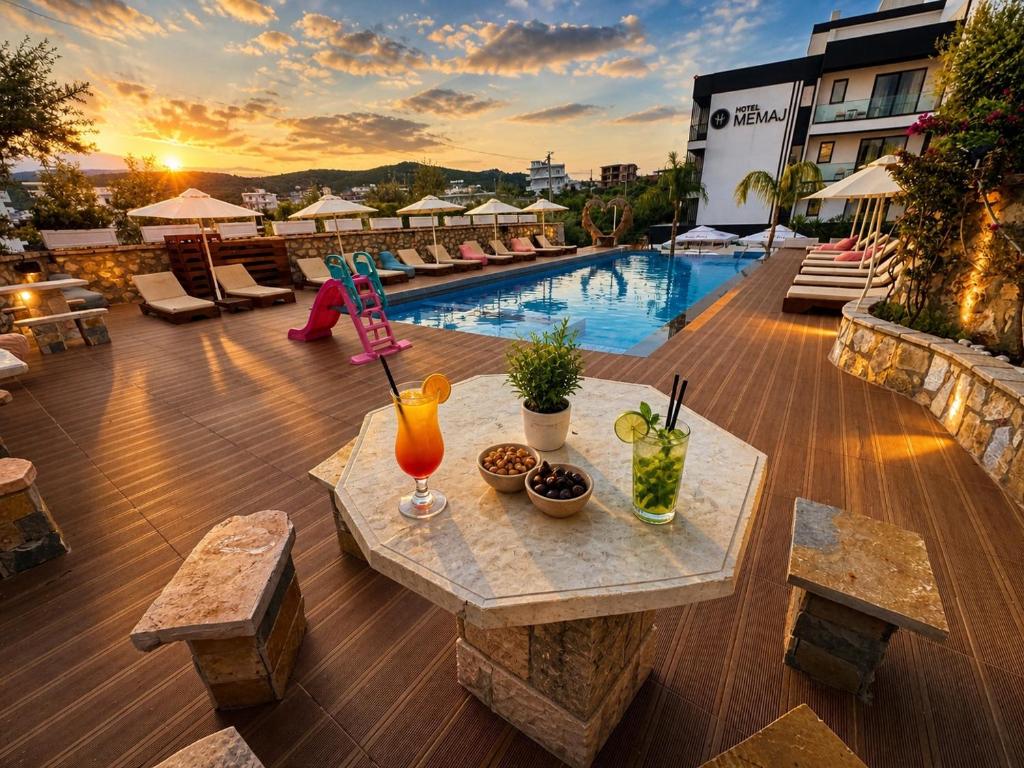 a patio with a table with drinks on top of a building at Hotel Memai Suites in Ksamil