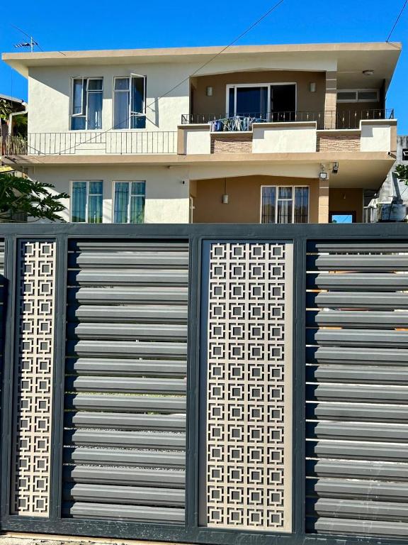 a house with a black and white fence in front at Shalom Villa 2 in Vacoas
